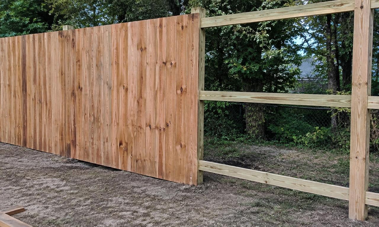 Privacy fence boards nailed tight onto horizontal rails between posts